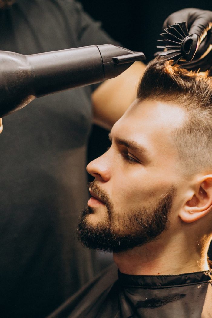 Handsome man at a barber shop styling hair